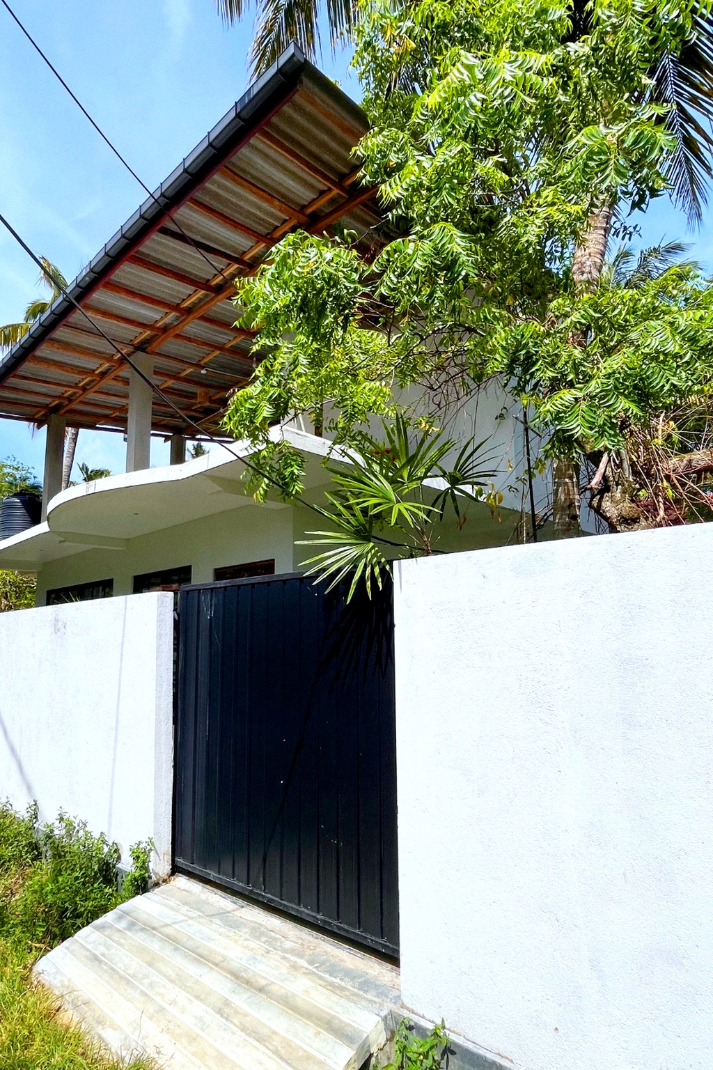 Casa street entrance · black gate and white wall