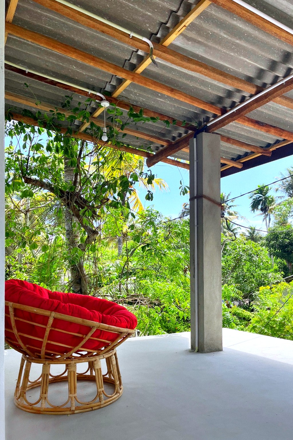 Casa rooftop terrace · red papasan chair under the timber roof