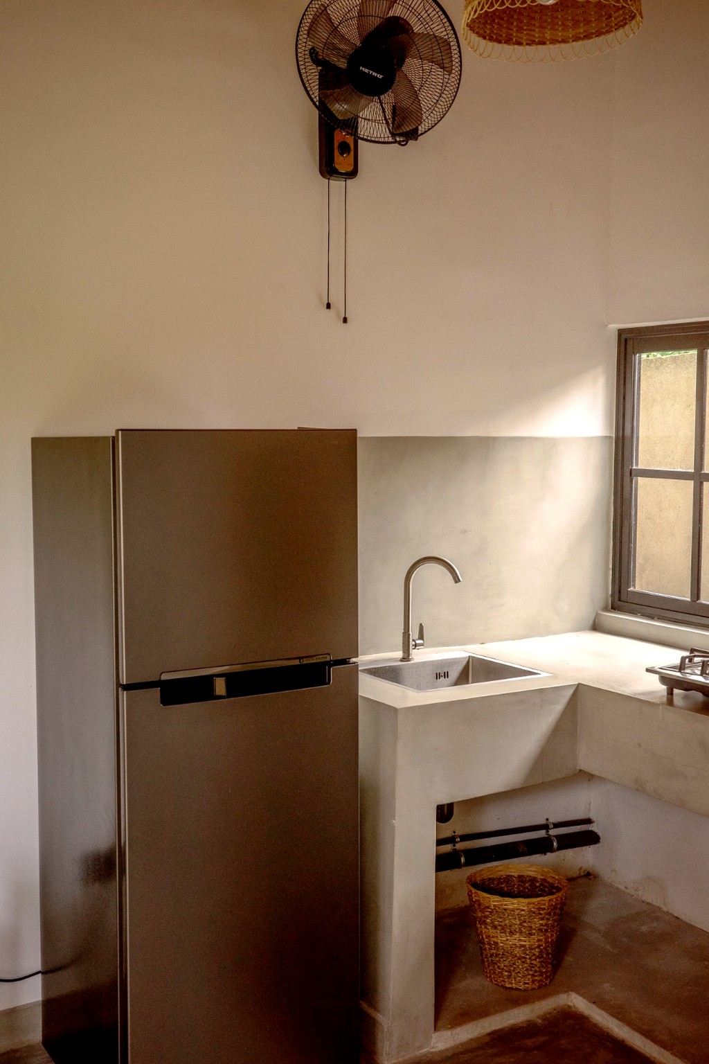 Casa kitchen · full fridge, concrete counter and wall fan
