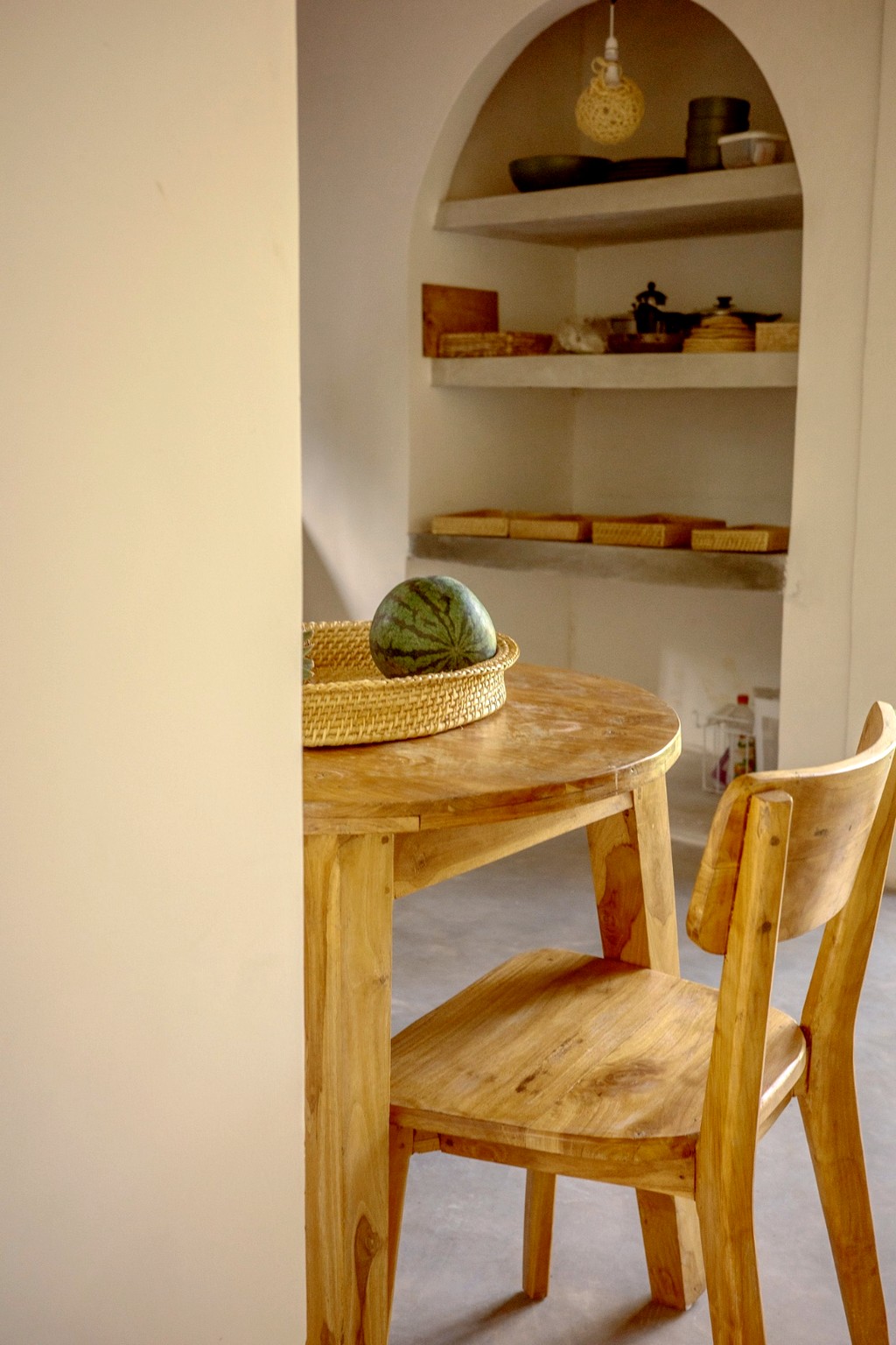 Casa dining · round teak table, watermelon basket, pantry arch