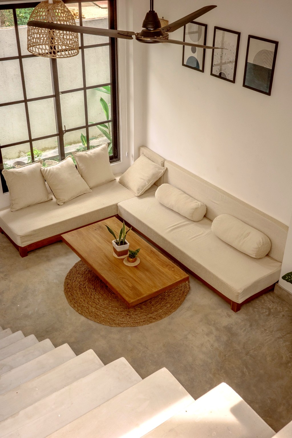 Casa living room from the stair landing · sofa, jute rug, grid window