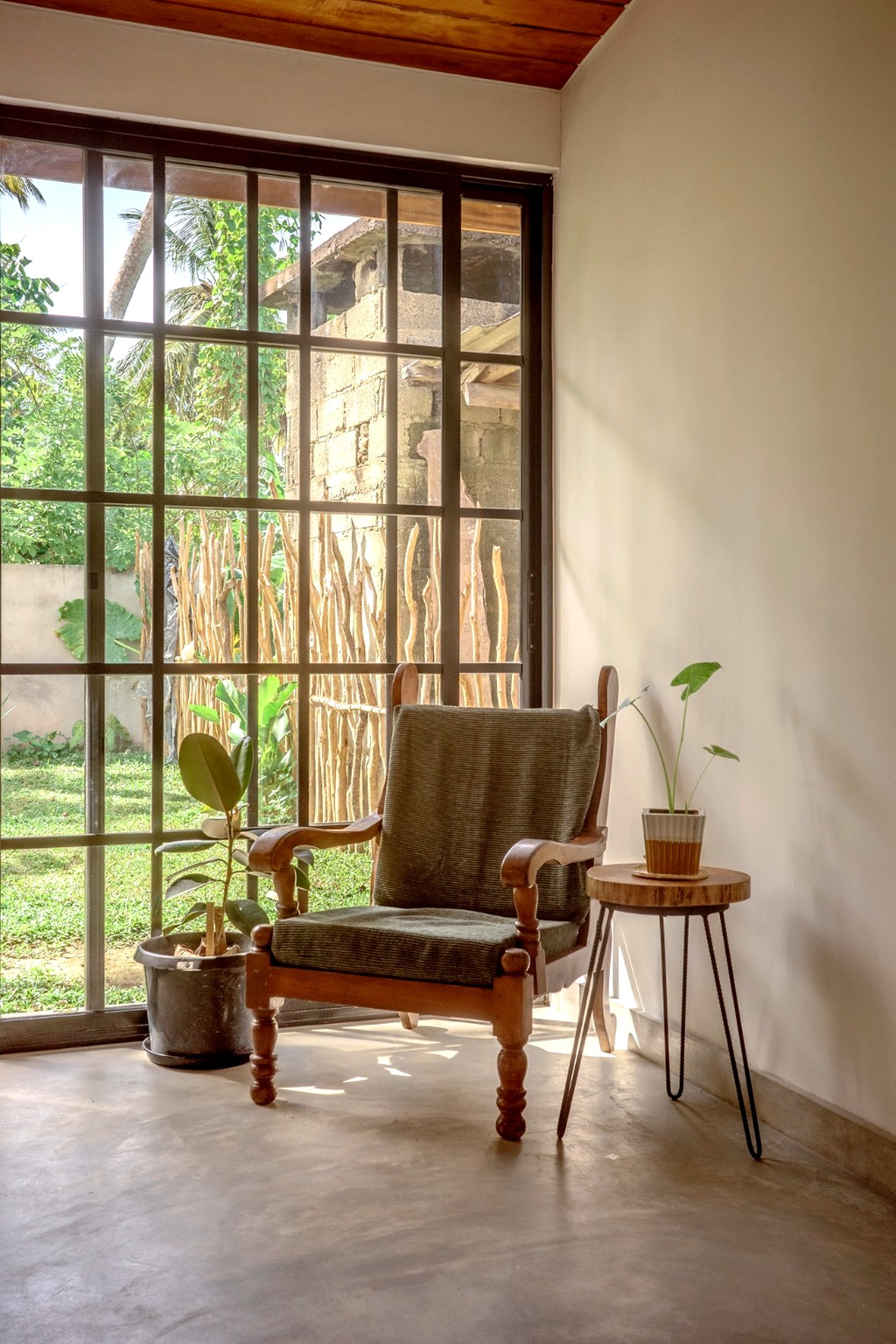 Casa reading corner · wooden armchair by the grid window