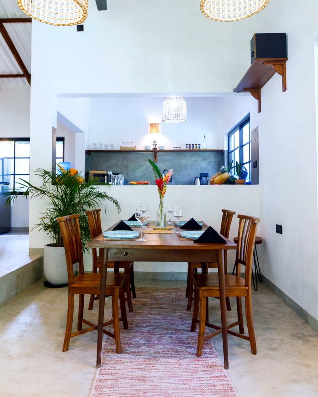 Safiya dining · woven pendants over the table, kitchen beyond