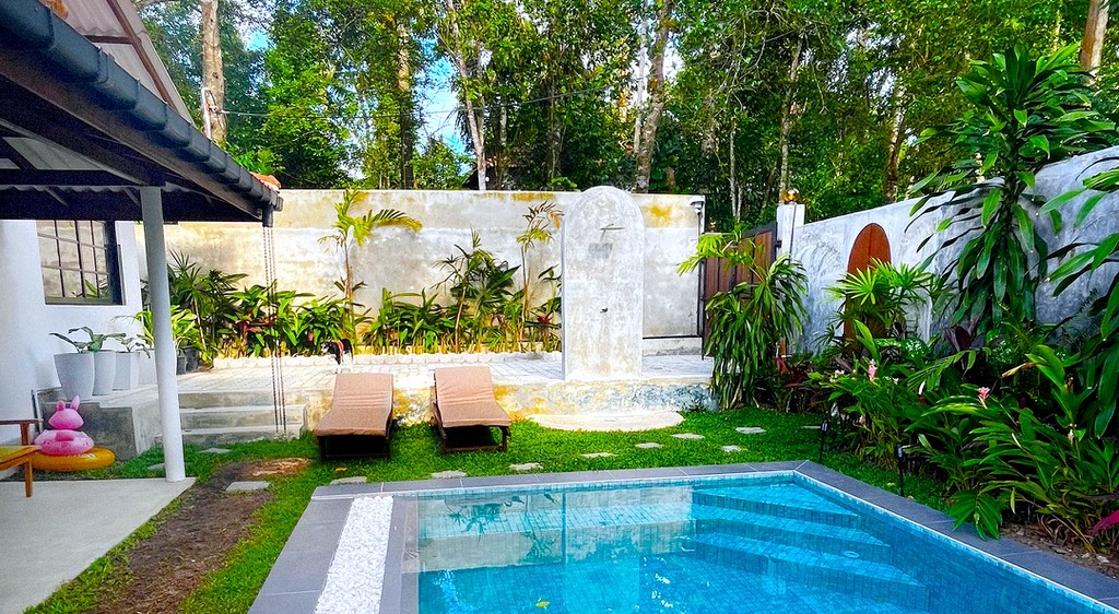 The pool and lawn at Domi Safiya, loungers in the sun