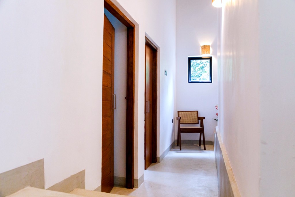 Safiya hallway · concrete floor, timber doors