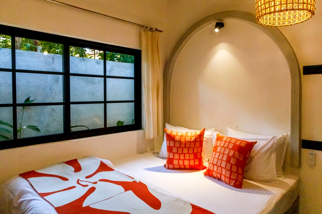 Safiya bedroom one · bed in the arched niche, grid window